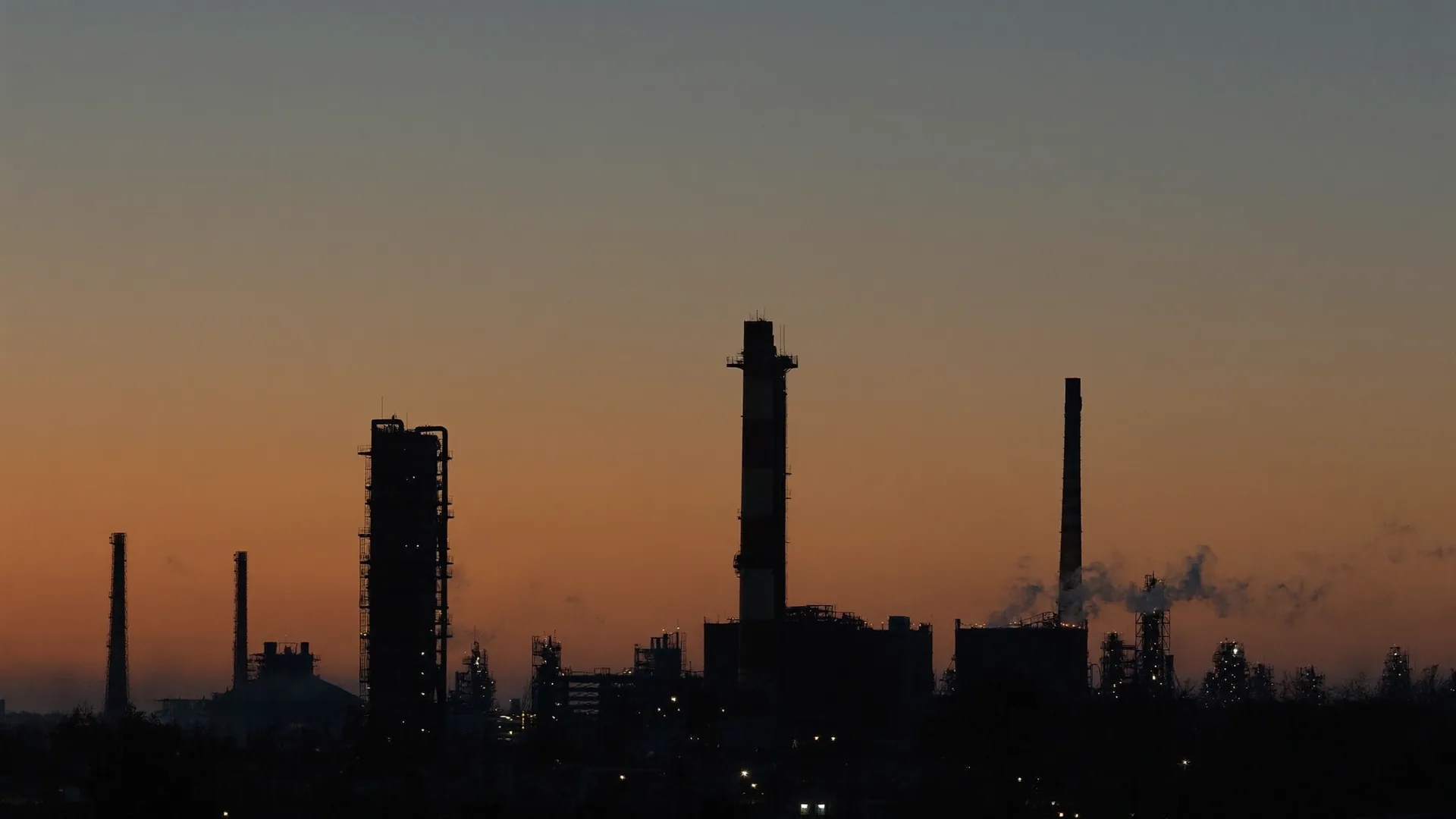 Industrial plant skyline silhouetted against a dusk sky