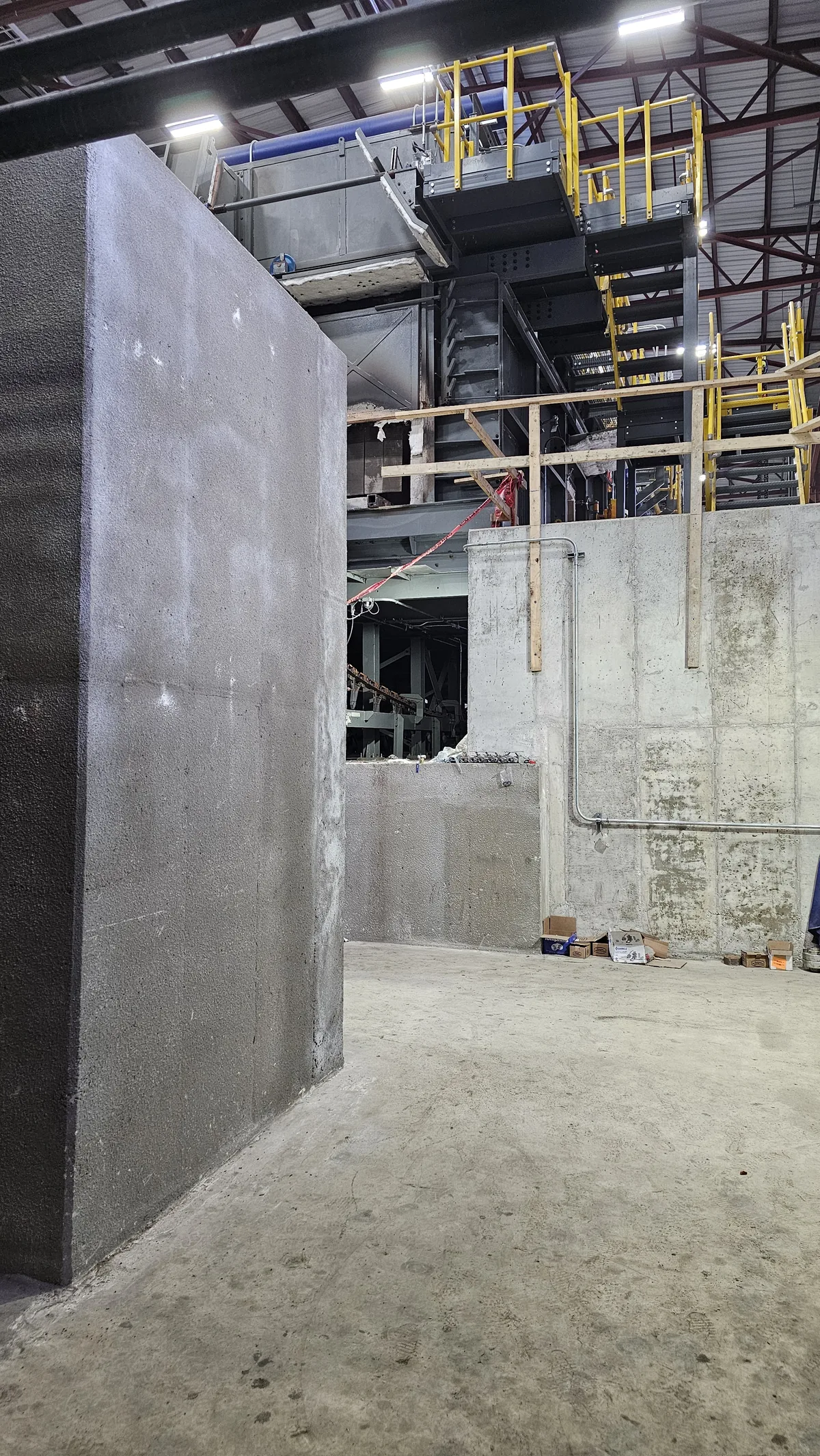 Tall cast-in-place concrete pit walls under the mill building steel