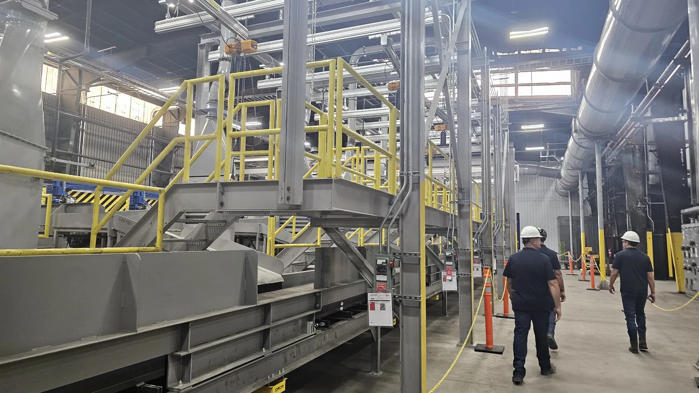 Elevated steel platform with handrail and stair alongside a conveyor line