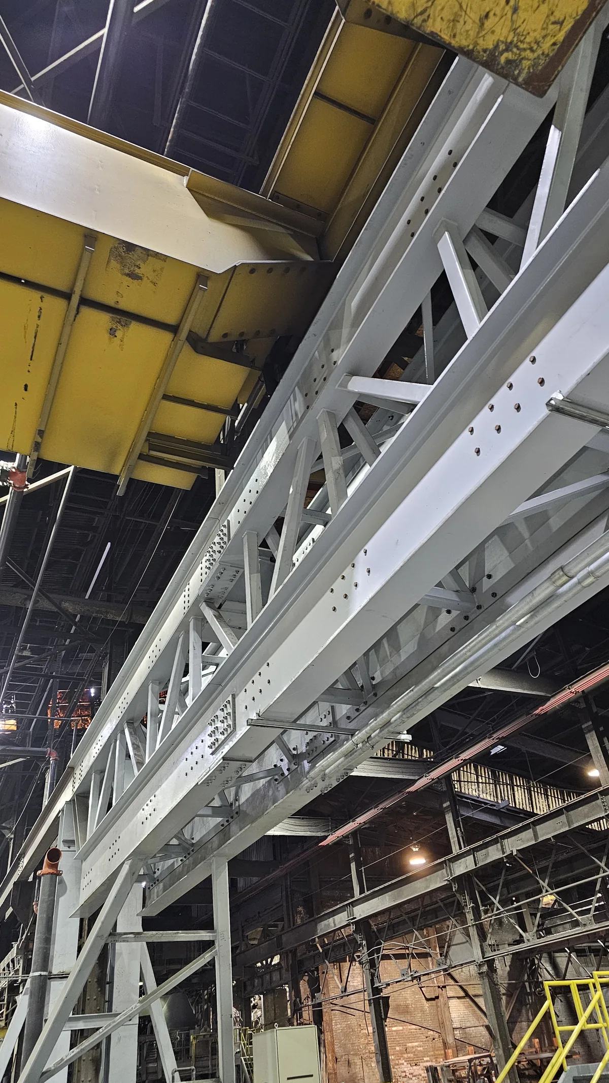 Fabricated steel truss girder installed overhead inside a mill building